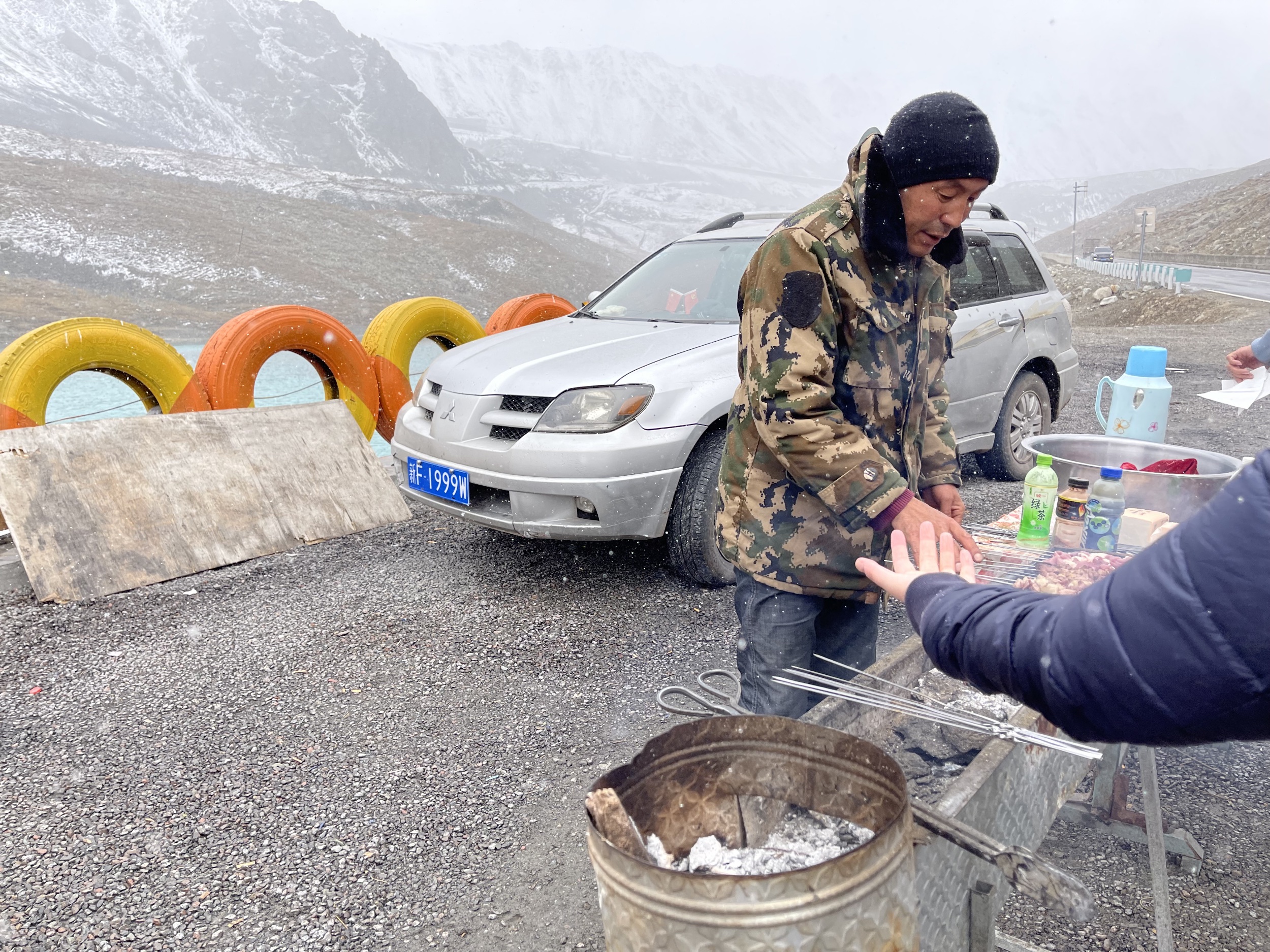 独库公路山上的湖泊和旁边的烤肉摊